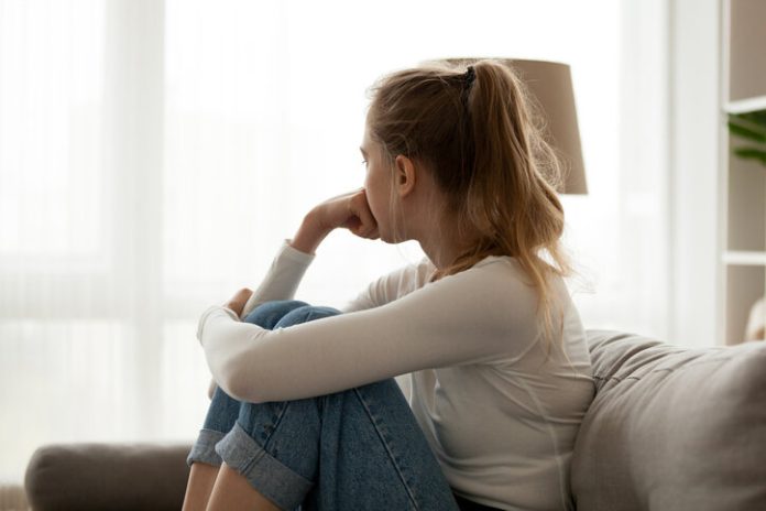 Upset woman sitting on couch alone at home upset woman sitting on couch alone at home